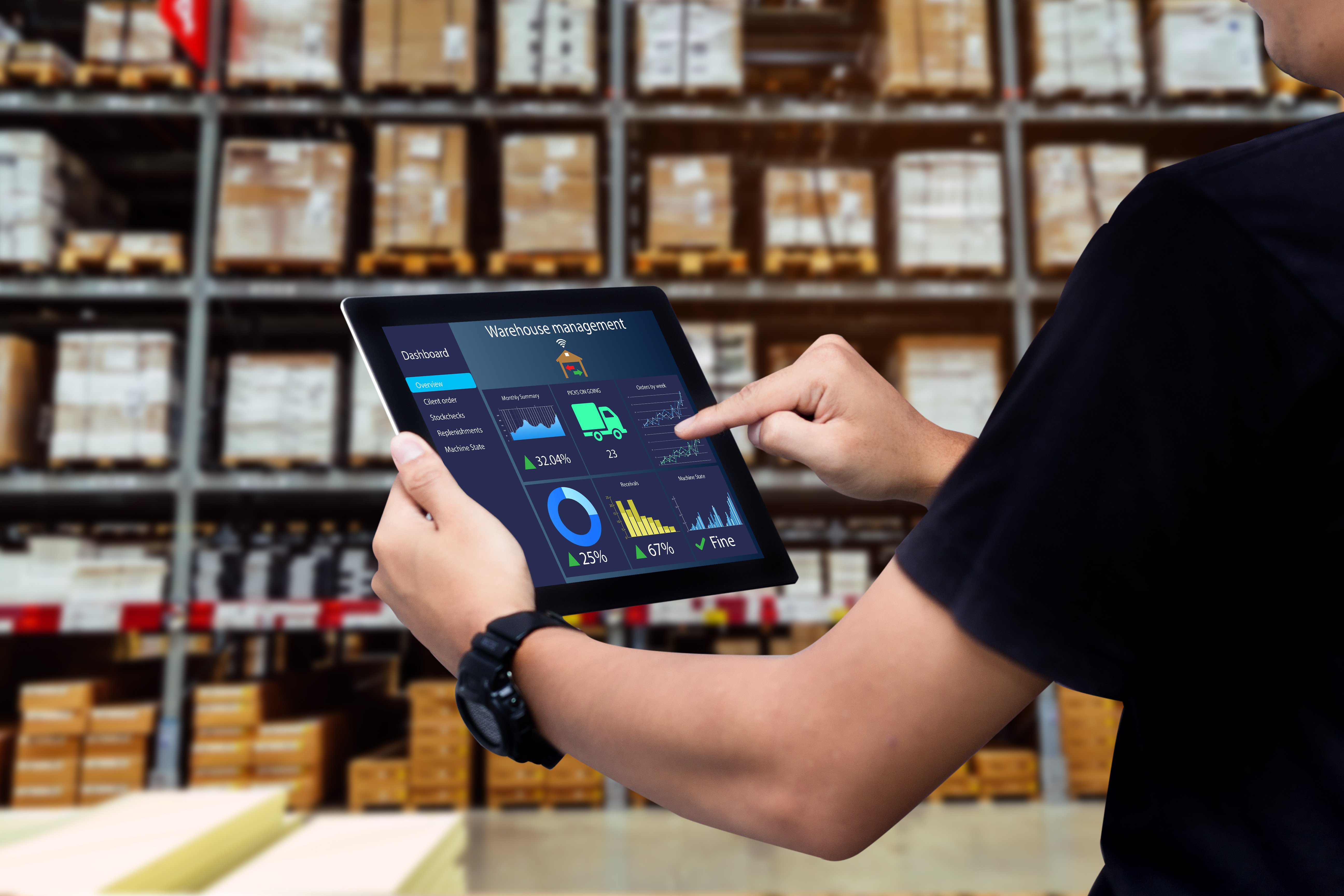 man monitoring warehouse inventory on an ipad