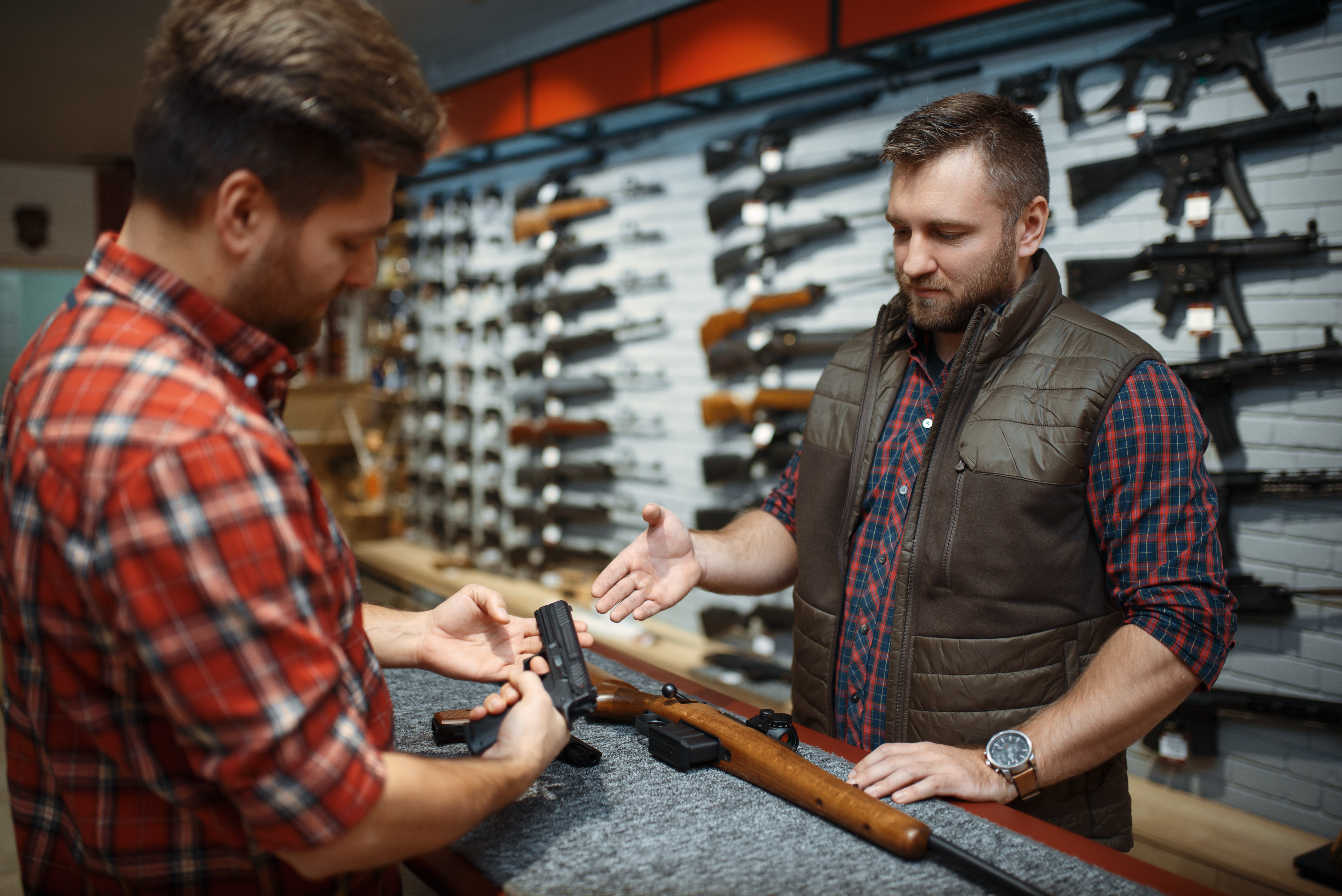 man looking at a firearm in a gun store